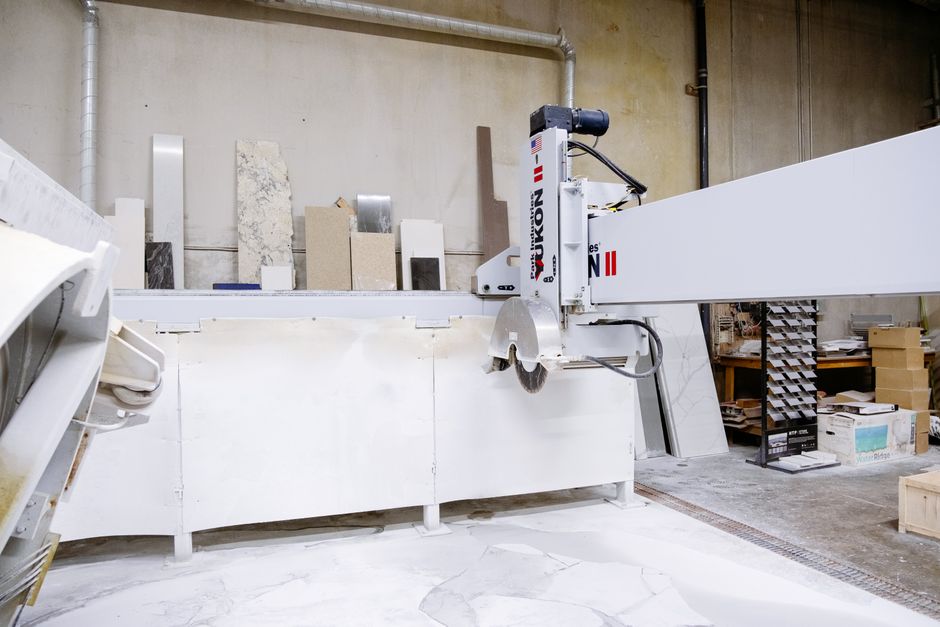 Stone fabricator cutting a granite slab